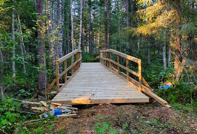 Kuvassa näkyy vasta rakennettu silta, jota pitkin ulkoilureitti ylittää ison ojan.